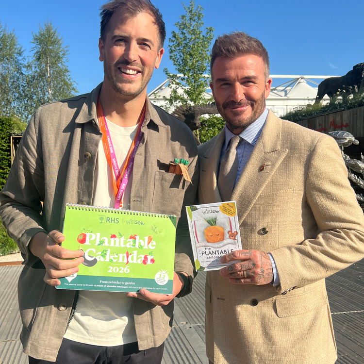 David Beckham holding Willsow plantable children’s book and RHS calendar with co-founder Tom Williams at Chelsea Flower Show.