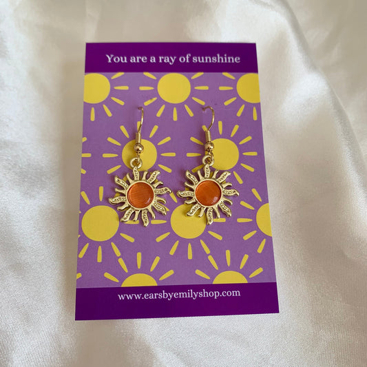 Gold and orange dangle earrings in gift bag on sunshine card