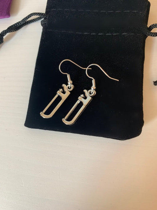 Silver hacksaw or saw earrings.