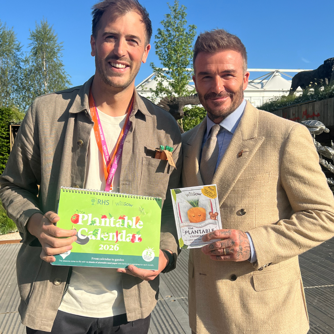 David Beckham holding Willsow plantable children’s book and RHS calendar with co-founder Tom Williams at Chelsea Flower Show.