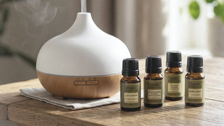Abbey Essentials pure essential oils displayed beside an aromatherapy diffuser in a relaxing home setting