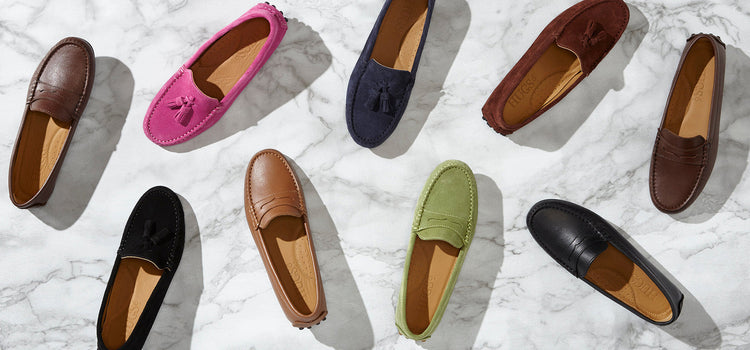 Hugs & Co. loafers in assorted colours arranged on a marble background