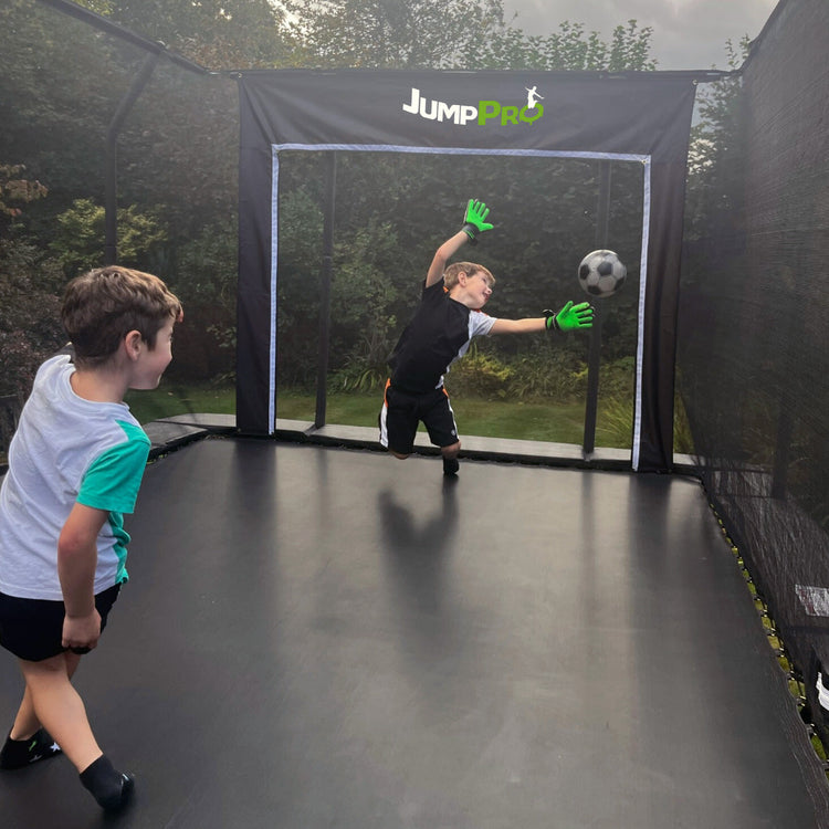 Children playing football on a JumpPRO trampoline football goal from MadFun