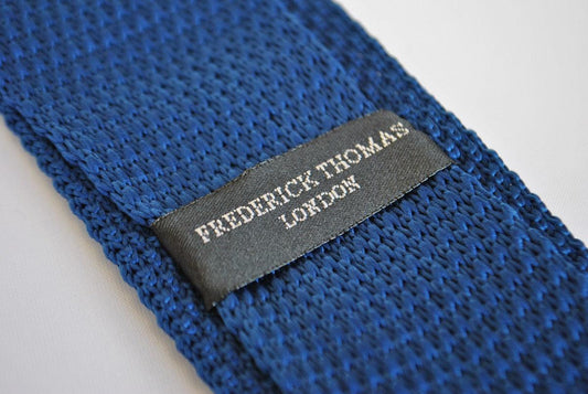 navy blue skinny knitted tie with white polka dots and pointed end
