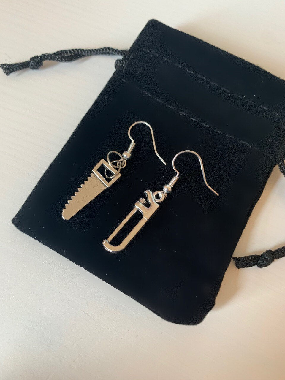 Silver hacksaw or saw earrings.