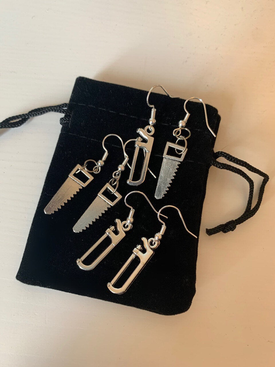 Silver hacksaw or saw earrings.