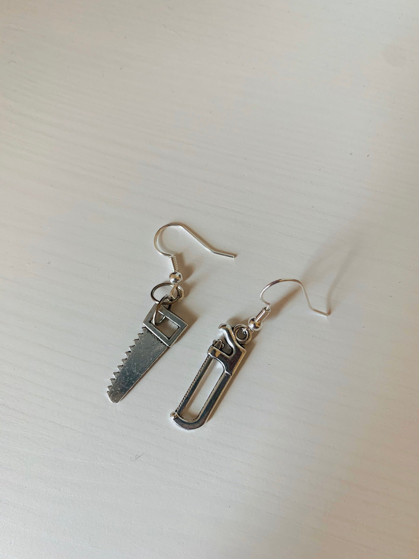 Silver hacksaw or saw earrings.