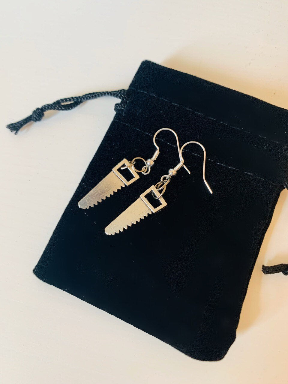 Silver hacksaw or saw earrings.