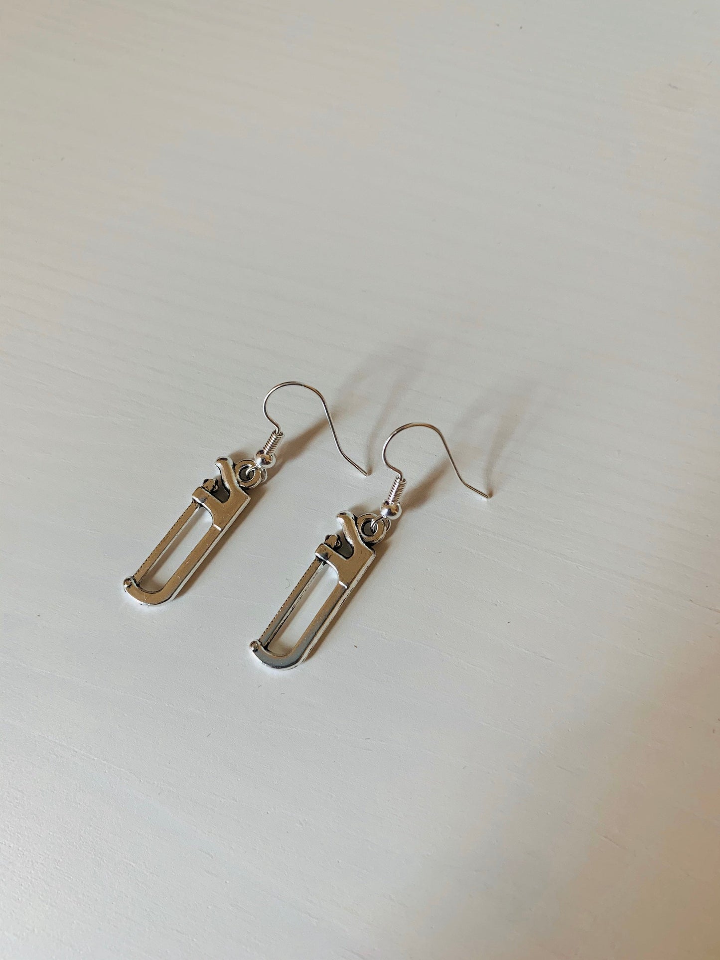 Silver hacksaw or saw earrings.