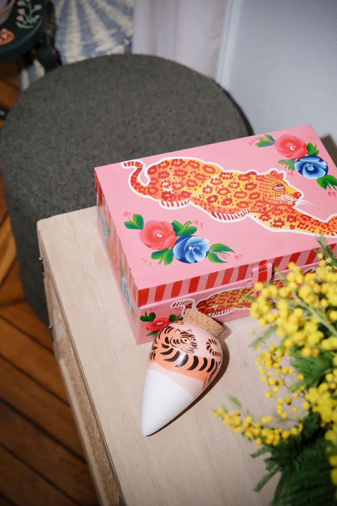Tiger Pepin Olla by Camille Gressier beside an illustrated tiger box and mimosa