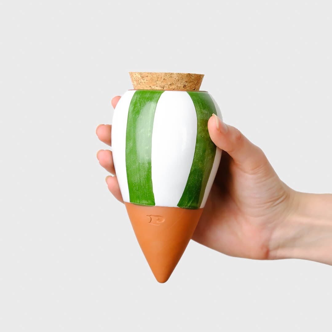 Pepin Olla with green and white stripes and terracotta tip, held in the hand