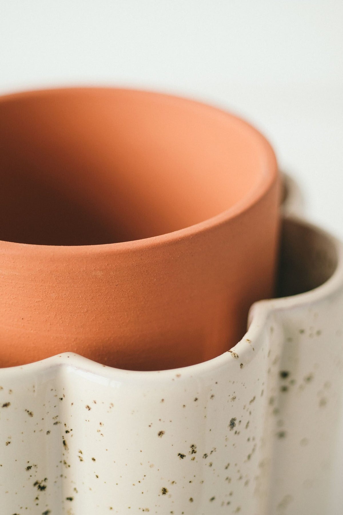 Close-up of the porous terracotta inner pot sitting in the speckled white Paulita reservoir