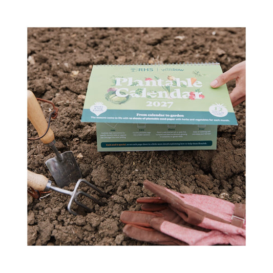 RHS & Willsow A4 Plantable Veg & Herb Desk Calendar 2027 front cover in the garden